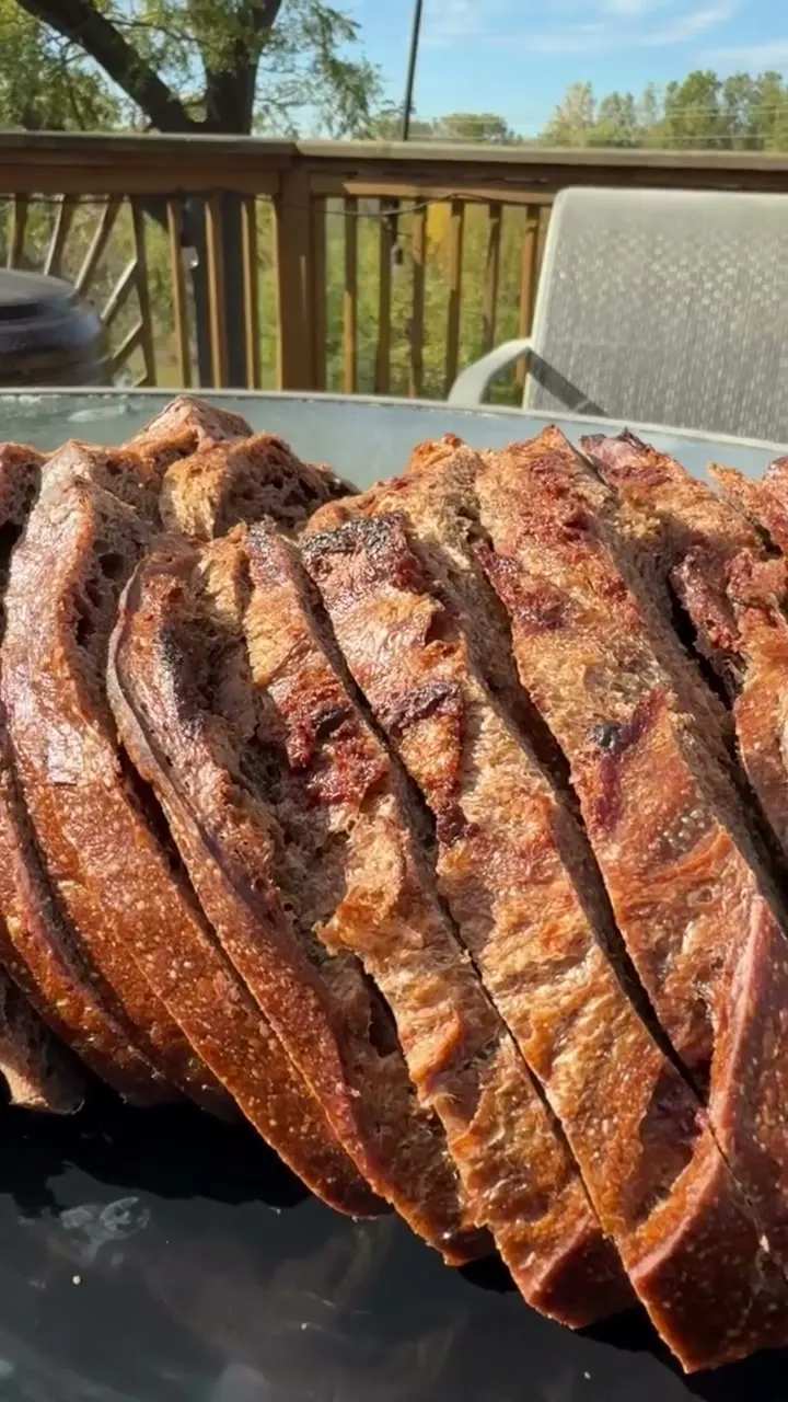 Dark crusted sourdough loaves sliced on a patio table