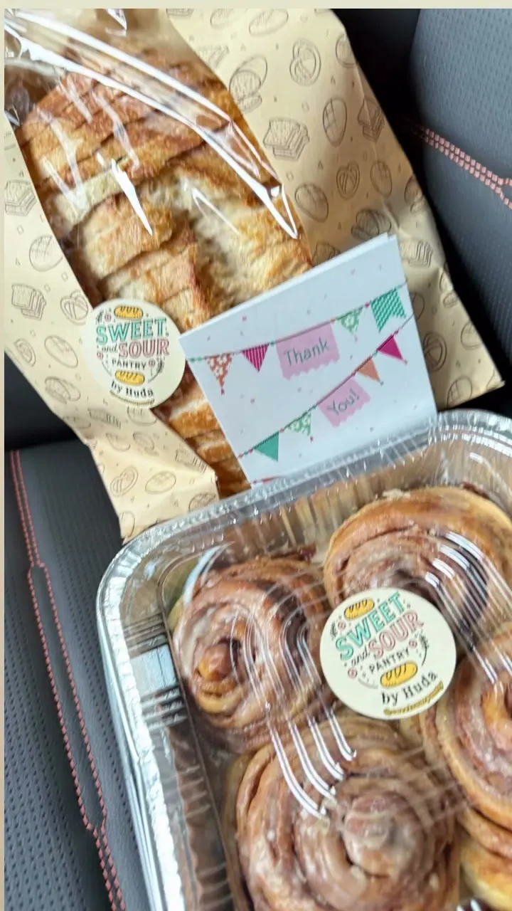 A gift bundle of bread and cinnamon rolls with a thank-you card